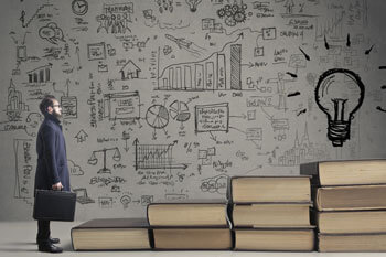 Geschäftsmann steht vor Treppe aus Büchern.