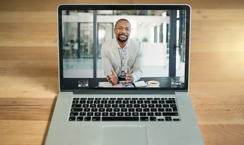 Ein Mann auf einem Laptopbildschirm ist zu erkennen, der im Rahmen eines Webinars etwas erklärt