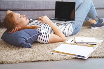 Studentin mit Laptop und Lernmaterial beim Selbststudium