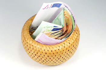 In einer Schale liegen viele Geldscheine mit hohen Beträgen