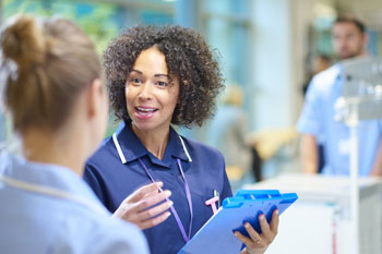 Gesundheitsmanagerin spricht mit einer Krankenpflegerin