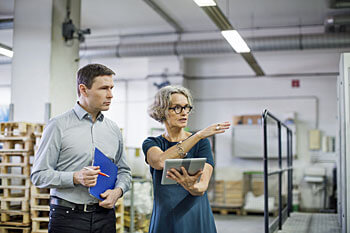 Supply Chain Managerin und Disponent bei der Arbeit.