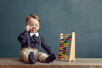 Kind sitzt vor Rechenschieber