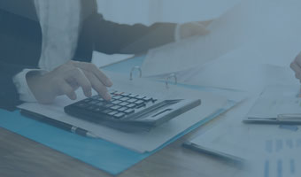 Eine Buchhalterin tippt etwas in einen Taschenrechner.