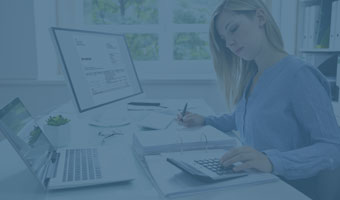 Buchhalterin prüft Rechnungen am PC