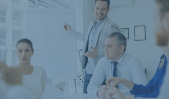 Ein Manager im Meeting erklärt etwas vor einem Whiteboard.