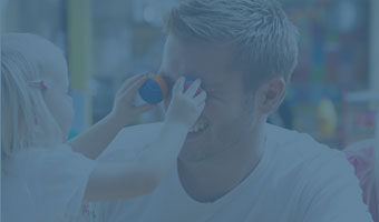 Ein Erzieher hat ein zweijähriges Kind auf dem Schoß