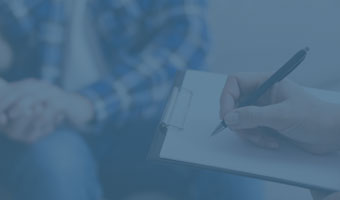 Psychologischer Berater ist mit zwei seiner Klienten im Gespräch und macht sich Notizen.