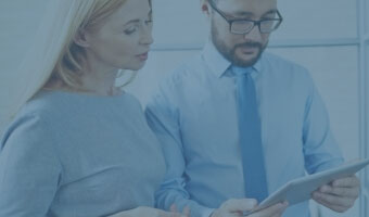 Zwei IT-Manager arbeiten an einem Tablet.