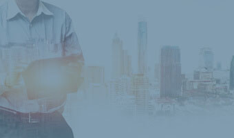 Ein Manager mit Tablet steht vor der Skyline einer Großstadt.