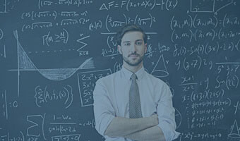 Ein Mathematiker steht vor einer Tafel, auf der mathematische Formeln zu sehen sind.