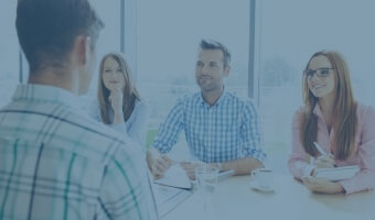 Drei Personalmanager führen ein Vorstellungsgespräch mit einem Bewerber.