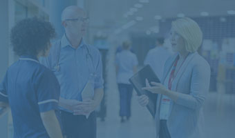 Eine Krankenschwester, ein Arzt und eine Managerin unterhalten sich in einem Krankenhaus.