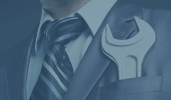 Ein Mann in Anzug und Krawatte trägt einen Schraubenschlüssel in der Brusttasche.